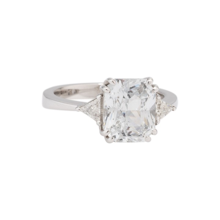 Damenring, bes. mit 1 weißen Ceylon-Saphir 5,52 cts. u. 2 Diam-Triangel zus. 0,23 ct. FW/VSI. 